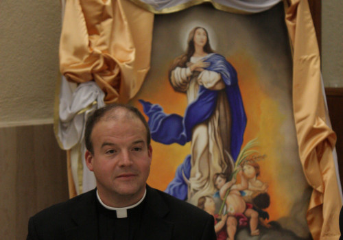 Rev. Peter Harman is pictured here in front of an image of Our Lady, given special prominence for this great Marian feast day.