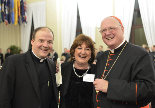 College Rector Peter Harman and past Rector Timothy Cardinal Dolan pose for a photo with Lory Mondaini, secretary for the Office of the Rector.